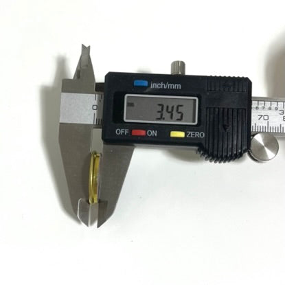 Digital caliper measuring a Baschieri and Pellagri 12 GA shotgun shell slice at 3.45 mm thick