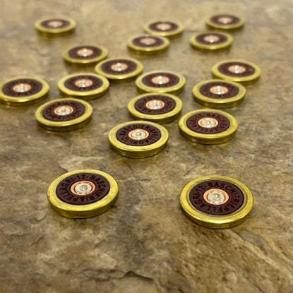 17 Baschieri and Pellagri 12 GA red shotgun shell slices with brass rims scattered on a white background