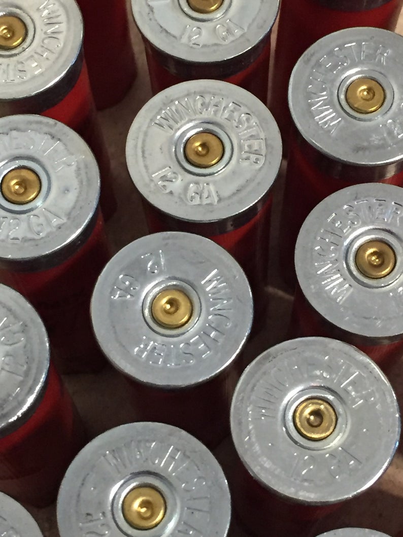 Silver Winchester 12 GA headstamps on a pile of red shotgun shells