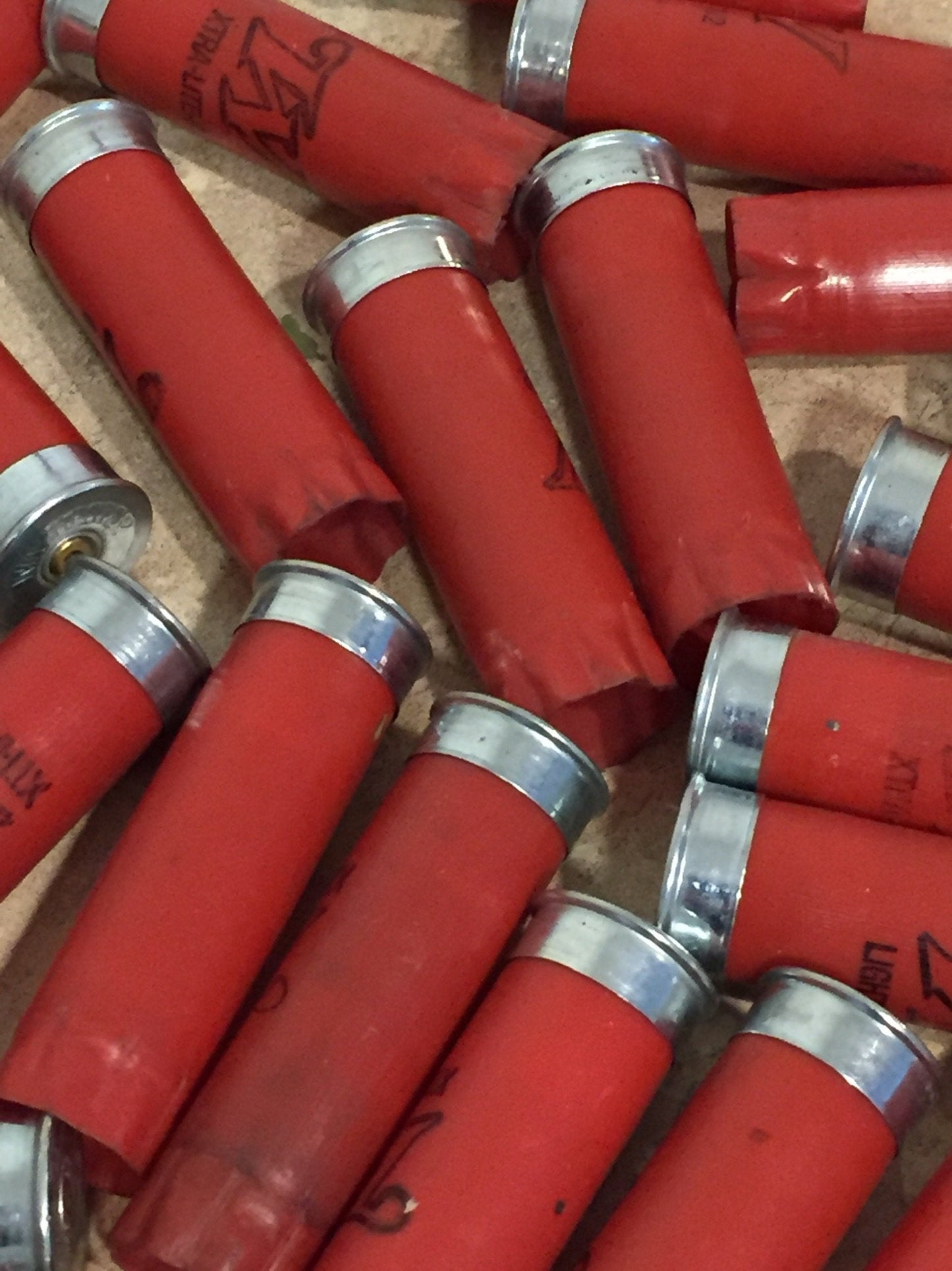 A pile of red Winchester shotgun shells with silver bottoms lying together