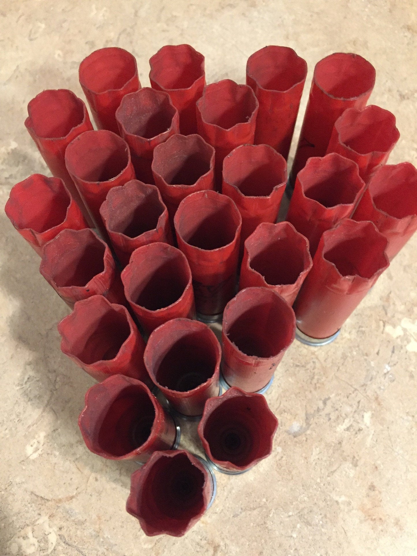 Many red Winchester shotgun shell hulls viewed from above showing open crimped tops