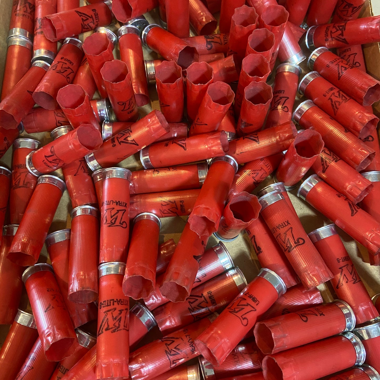 Bin of used red Winchester 12 gauge shotgun shell hulls