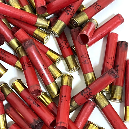 Red Winchester AA 410 bore shotgun shell hulls piled together, marked with various headstamp codes