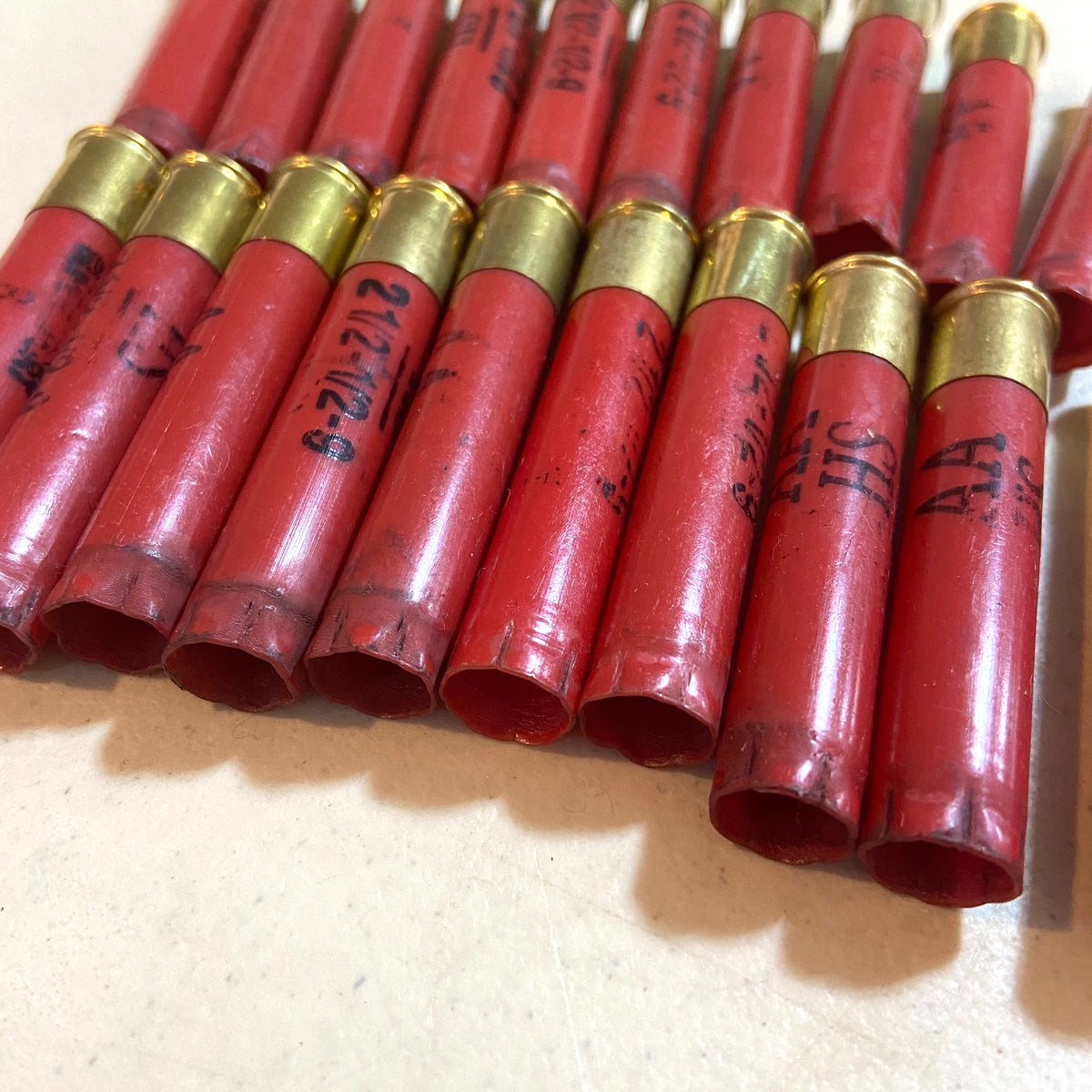 Red Winchester AA 410 bore shotgun shell hulls in a row with open ends bundled together