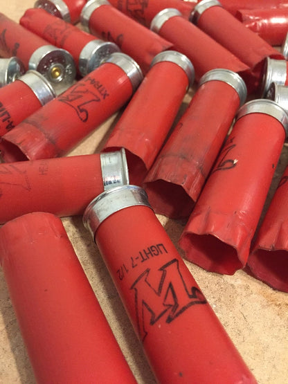 A pile of red Winchester shotgun shells with silver bottoms marked LIGHT-7 1/2