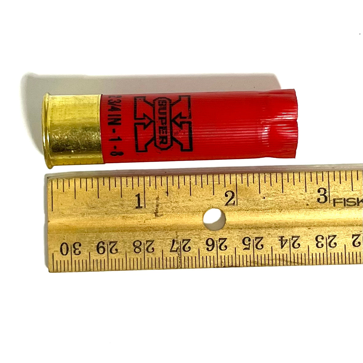 Red Winchester Super X 16 gauge shotgun shell with brass base measured against a ruler showing approximately 2.75 inches
