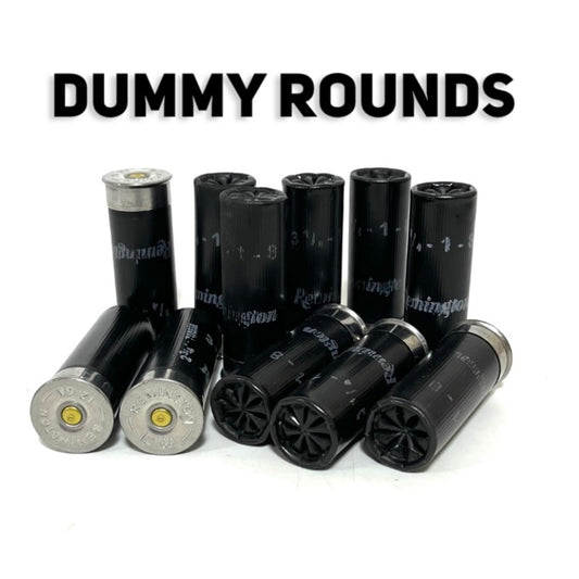 Black Remington 12 gauge once-fired dummy rounds standing and lying, crimps and silver bases out, under a Dummy Rounds title