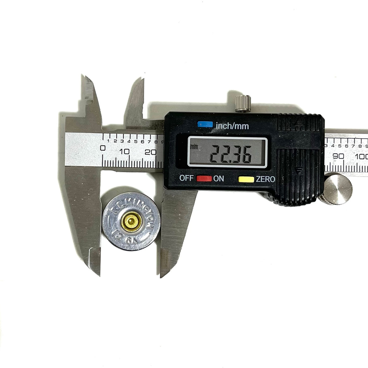 Digital caliper measuring the diameter of a Remington 12 gauge bullet slice at 22.36 millimeters, with the "REMINGTON 12 GA" headstamp visible
