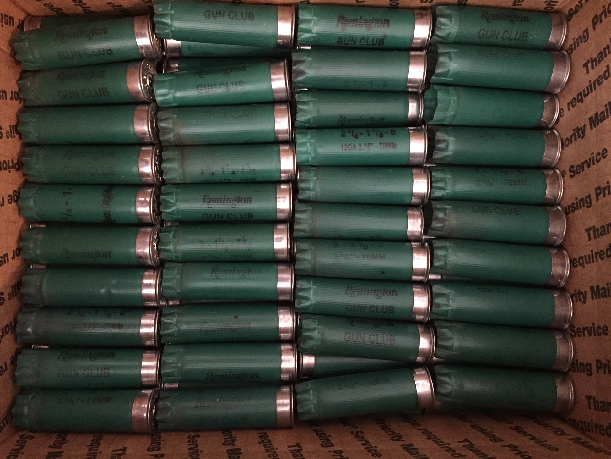 Rows of green Remington Gun Club 12 gauge shotgun shell hulls packed in a shipping box