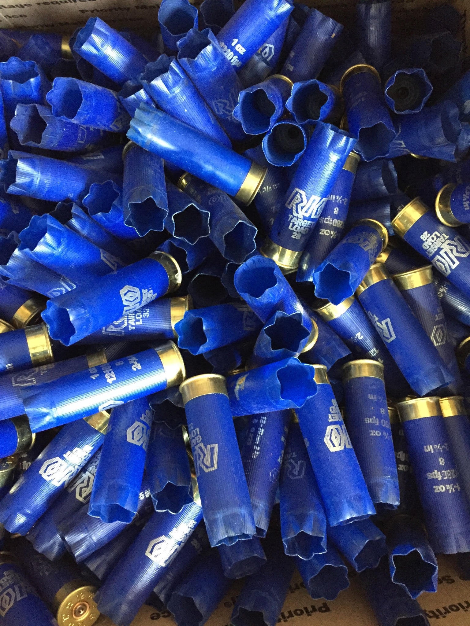 Pile of once-fired blue RIO 12ga empty shotgun hulls for crafting projects