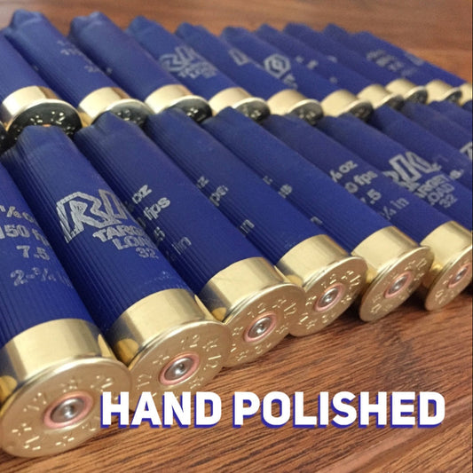 Row of blue Rio 12 gauge shotgun shell hulls with brass bases and a bold "HAND POLISHED" text overlay