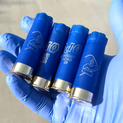 Four blue Rio 12 gauge shotgun shell hulls held in a gloved hand showing "RIO Target Load 28" print