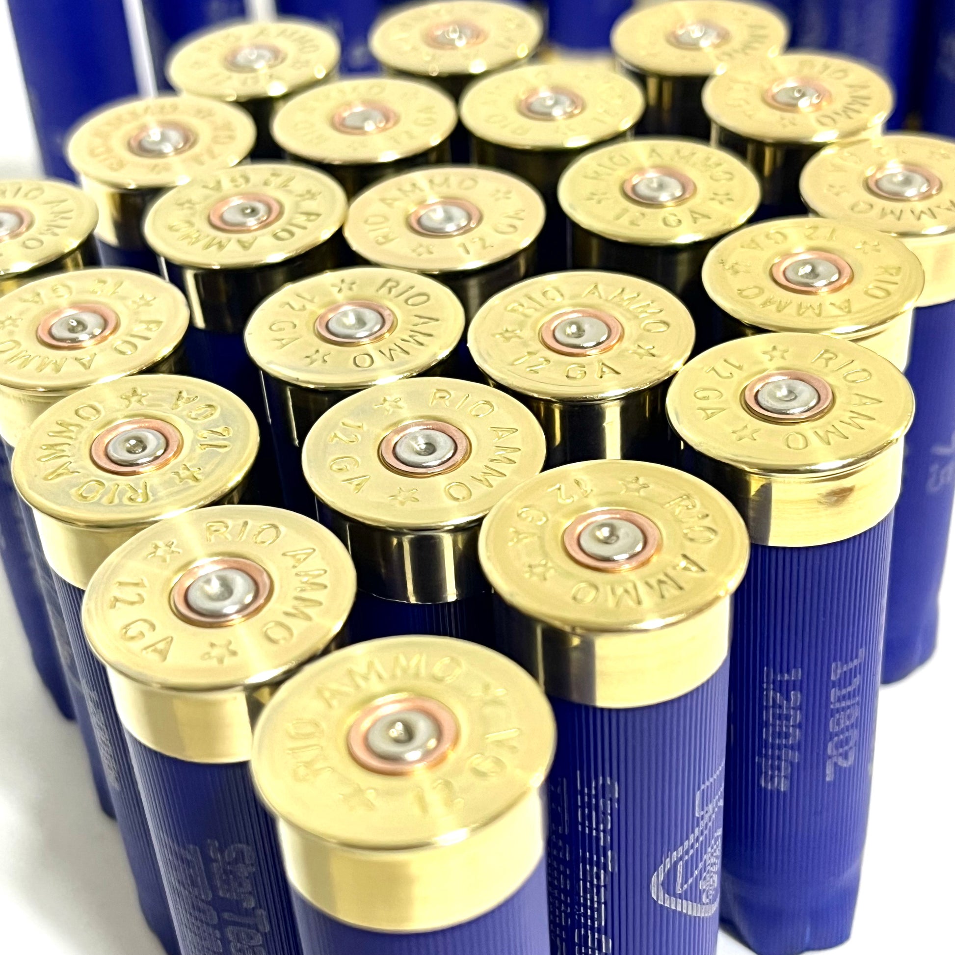 Cluster of blue Rio 12 gauge shotgun shell hulls viewed from above showing brass "RIO Ammo 12 GA" headstamps