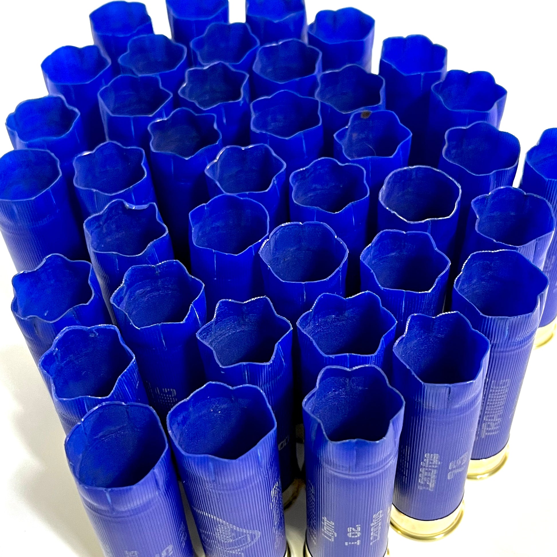 Large cluster of blue Rio 12 gauge shotgun shell hulls viewed from above showing open flower-crimped mouths