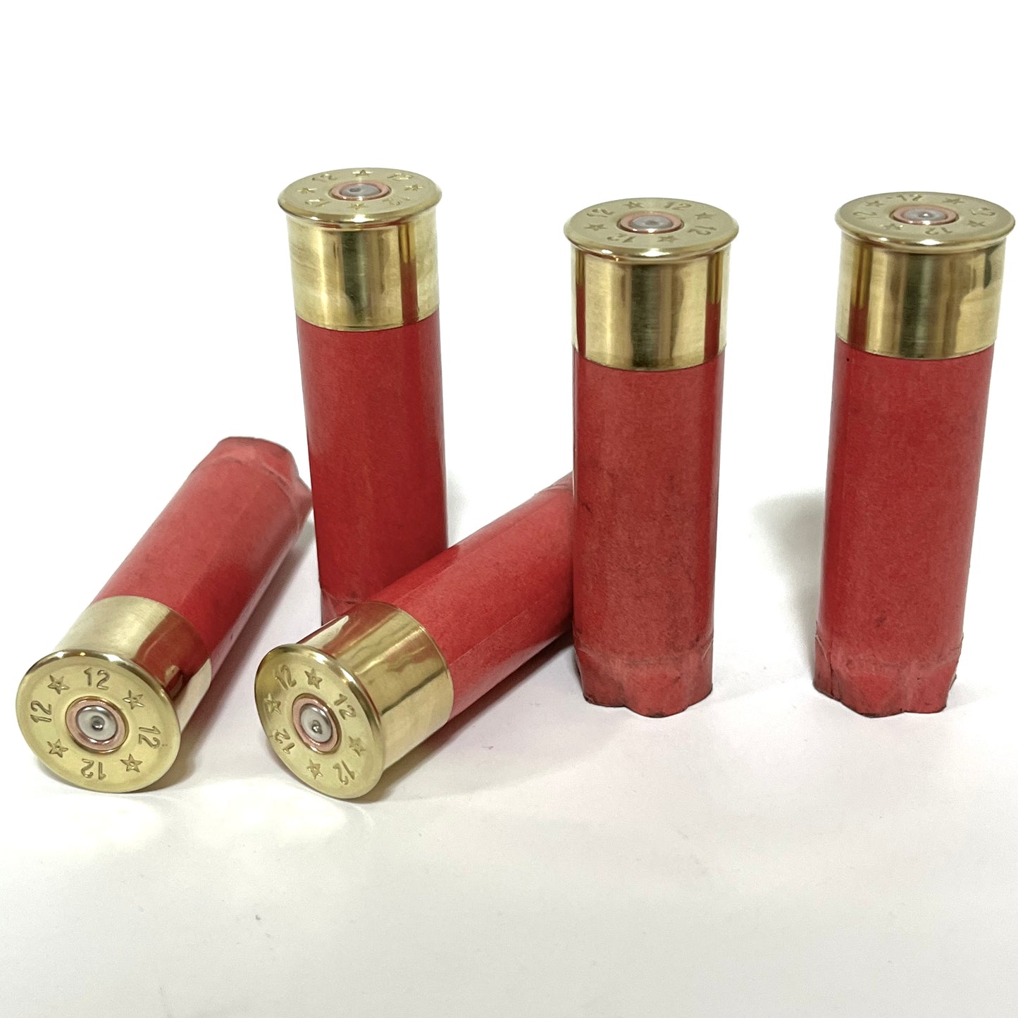 4 salmon pink paper shotgun shells with gold brass heads standing on a white background