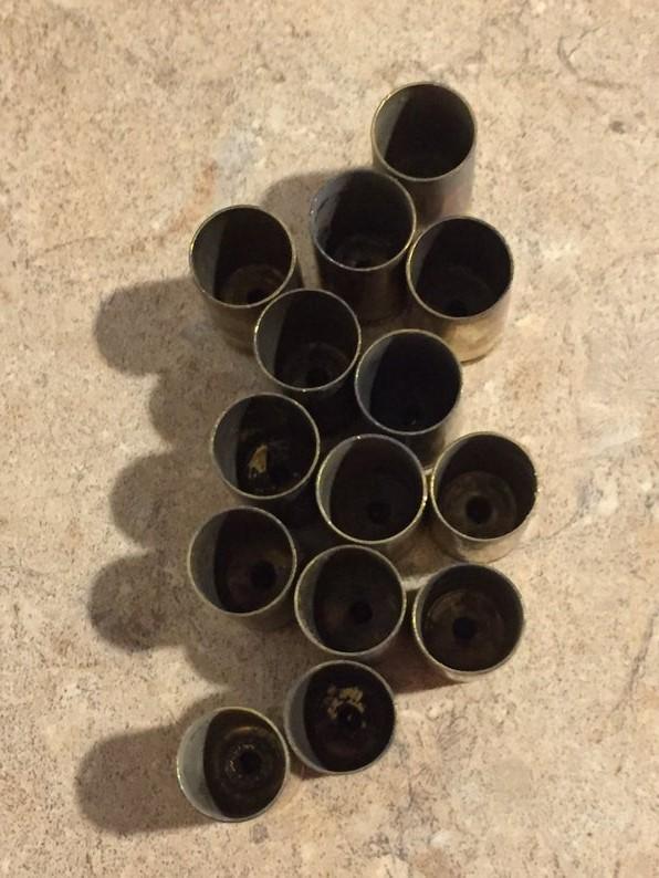 Cluster of brass shells with open mouths facing up on a textured stone surface