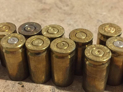 Row of brass shells standing upright with gold and silver primers visible on top