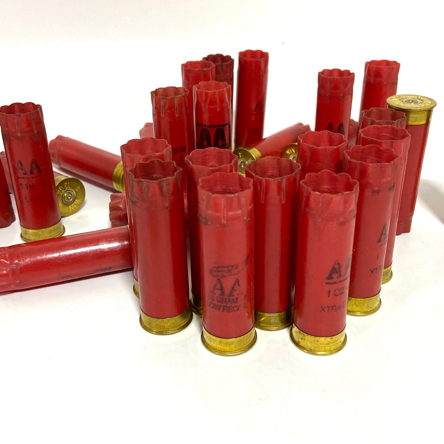 Red shotgun hulls in a small cluster, some standing and some lying flat, with AA markings visible