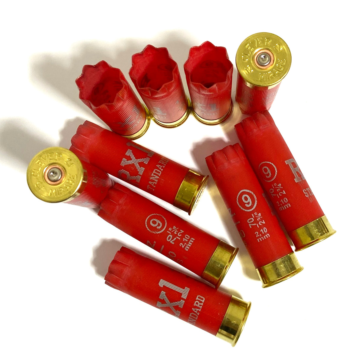 Eight bright red Clever Mirage 12 gauge shotgun shells with gold bases arranged in a circle showing headstamps