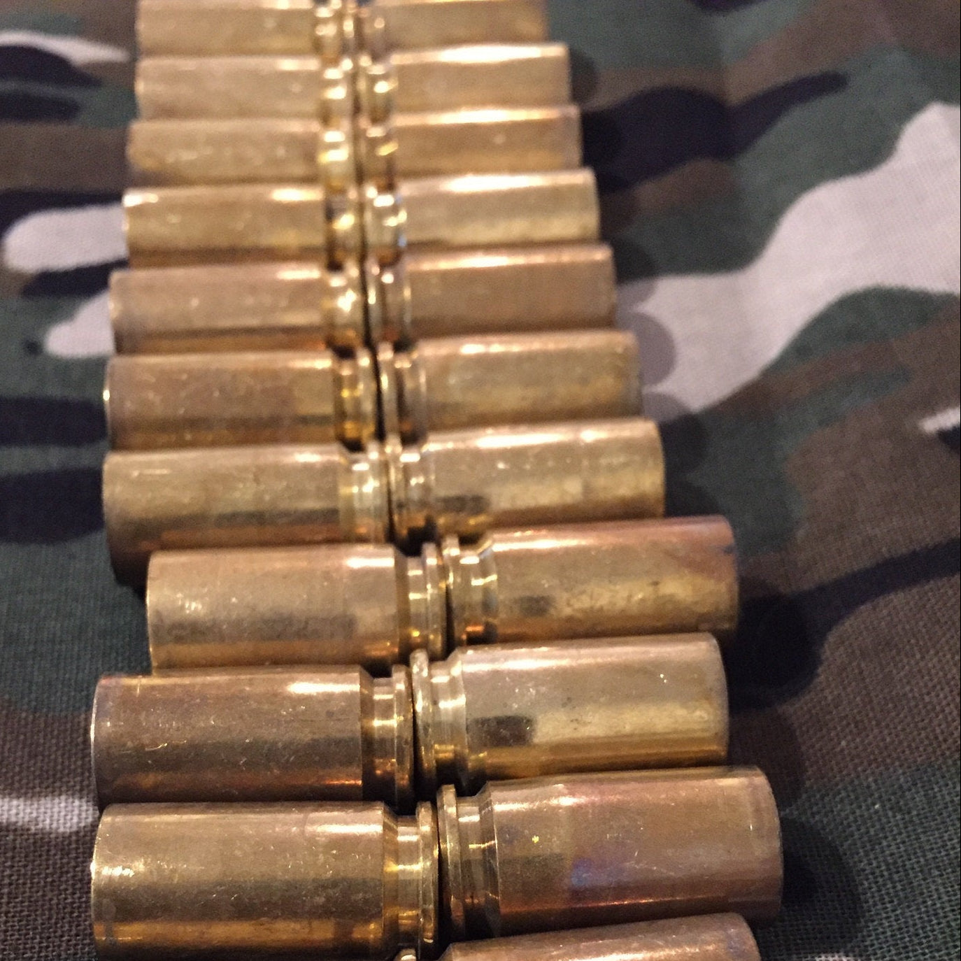 40 caliber spent casings in two rows on camouflage fabric backdrop 