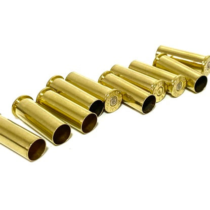 Row of polished brass 38 Special empty shell casings arranged in a zigzag on white background