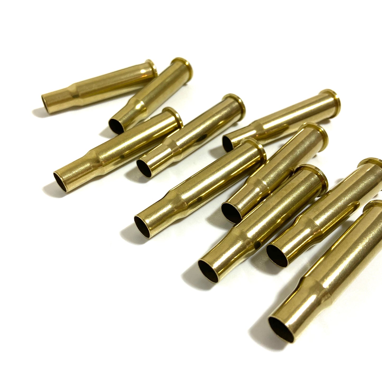 Polished 30-30 brass casings for steampunk crafting and bullet jewelry making, bright yellow-gold tumbled shells.
