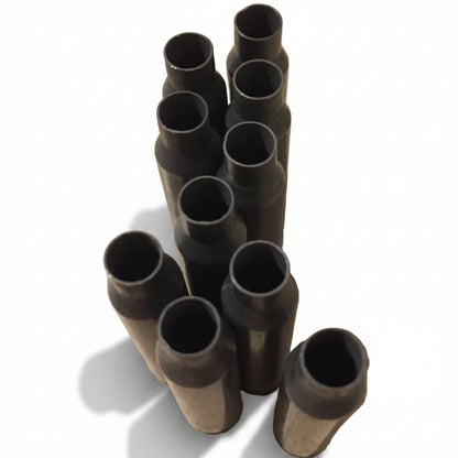 A cluster of dark gray used steel .223/5.56 empty casings standing case mouths -up white background