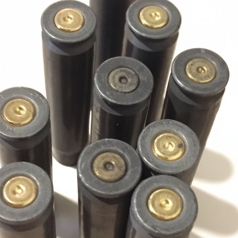 A tight cluster of dark gray steel .223/5.56 empty casings standing base-up, most with brass-colored spent primers