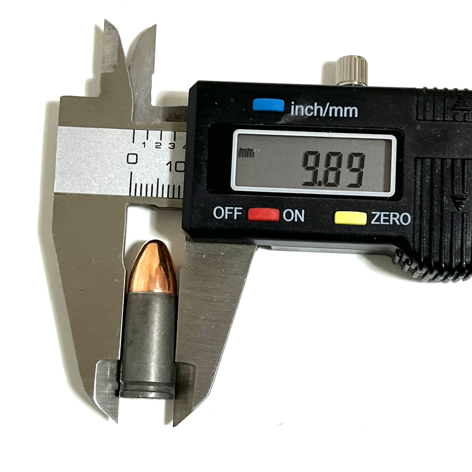 A single gray steel 9mm dummy round measured with digital calipers reading 9.89 mm