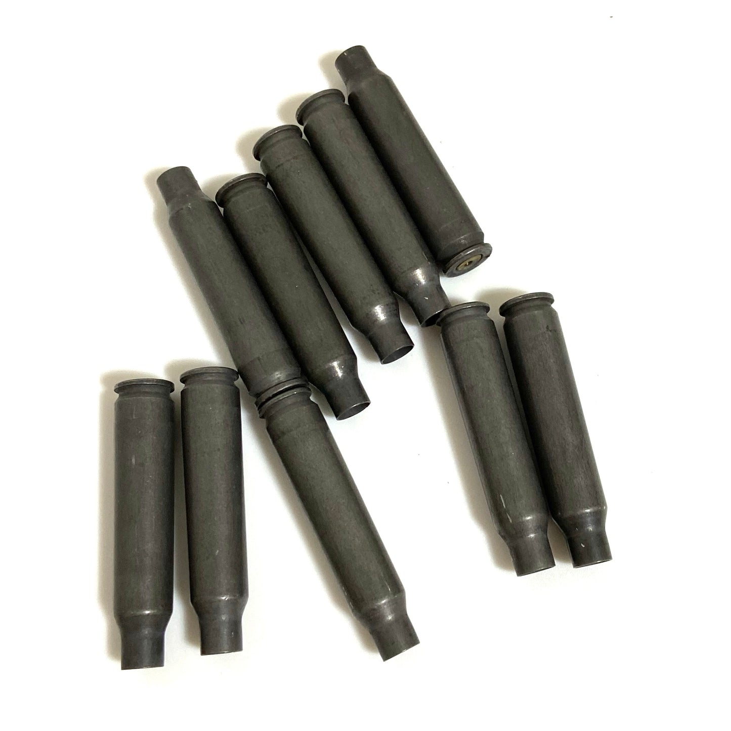 A loose bundle of dark gray steel .223/5.56 empty shells fanned across a white background
