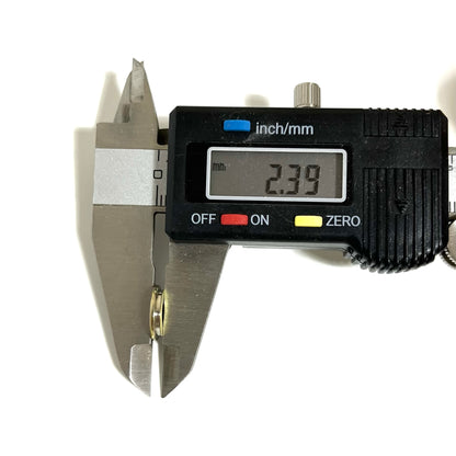 A digital caliper measuring the thickness of a thin cut bullet slice showing 2.39 mm on the screen.