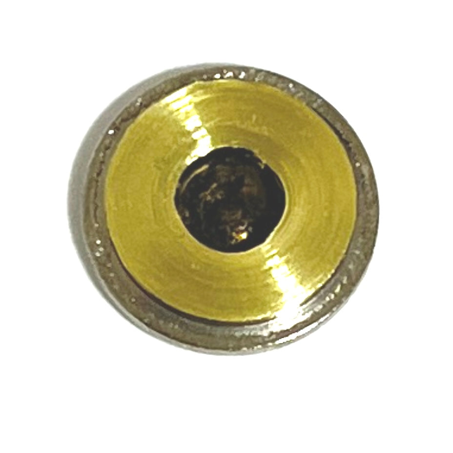 A close-up view of the back side of a thin cut bullet slice showing the inner brass primer pocket and smooth edges. .