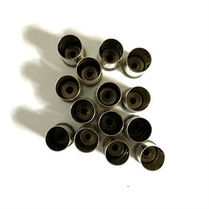 Overhead view of 13 polished nickel 38 Special brass casings viewed open-end up