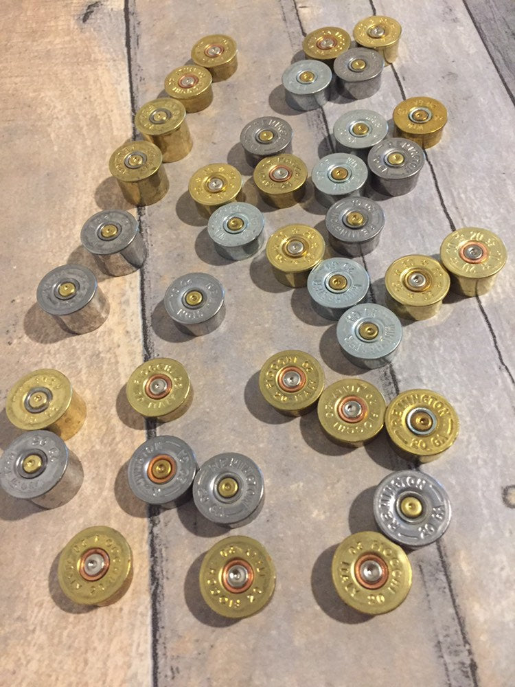Grouped 20 gauge shotshell casing ends in gold and silver colors.