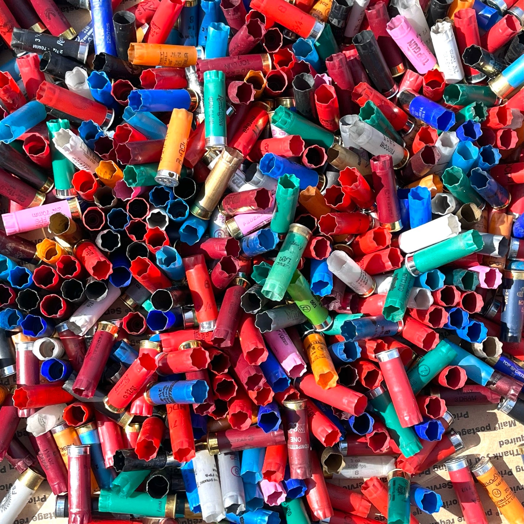 Top-down view of multi-colored 12ga shells. Inert 12ga shells for crafts (no powder/primers).
