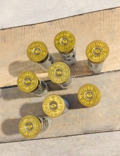 8 white Federal 12 gauge shotgun shells viewed from above showing brass headstamps