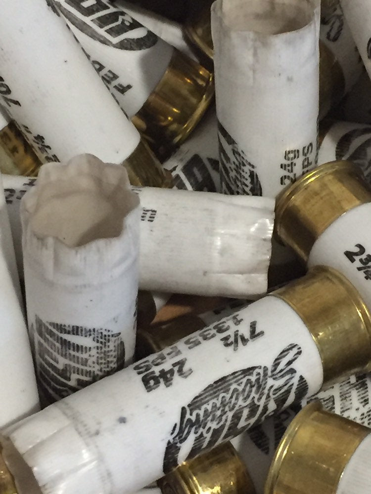 Close-up pile of white Federal 12 gauge shotgun shells with brass bases