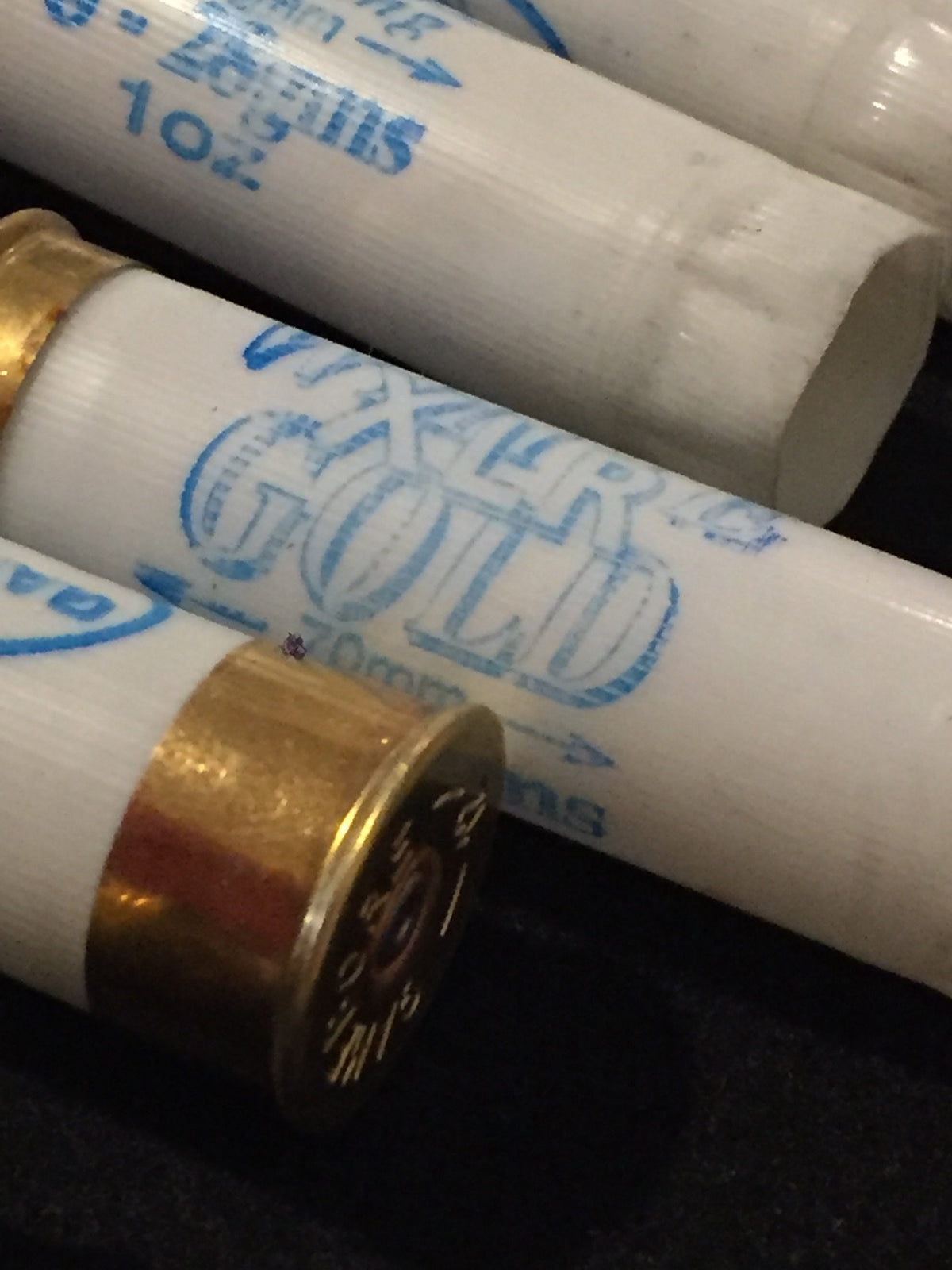 Close-up of white shotgun shells with brass bases showing "White Gold" printed text