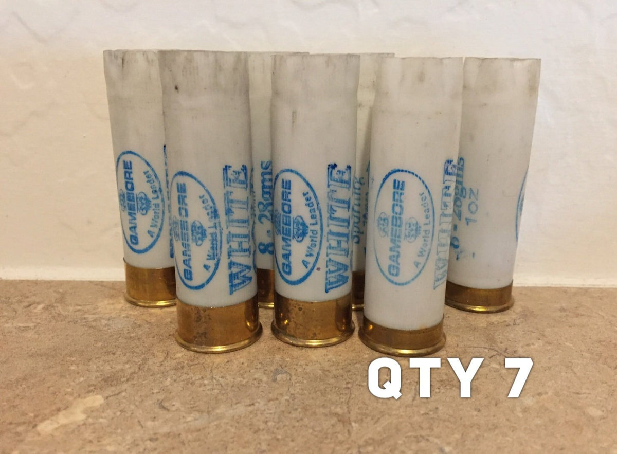 7 white shotgun shells with brass bases standing upright, printed "Gamebore" and "White" text, with "QTY 7" text overlay