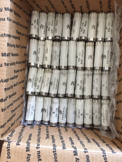 Rows of white Federal Top Gun shotgun shells packed inside a Priority Mail shipping box