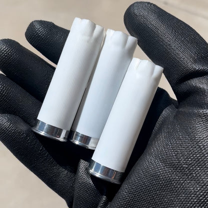 Three once-fired Stars & Stripes 12 gauge white shotgun shells with silver bases held in a black gloved hand