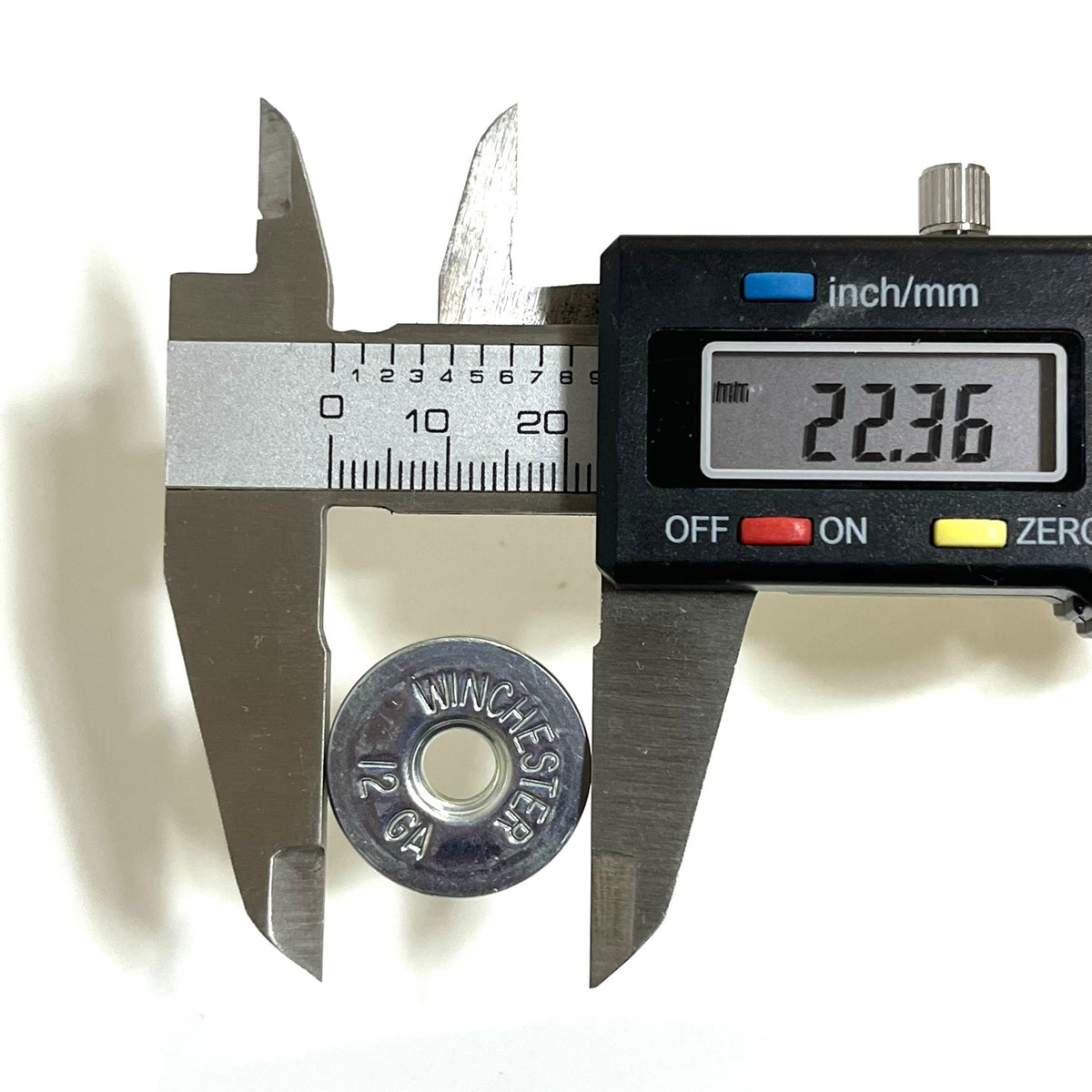 Digital caliper reading 22.36mm beside a silver Winchester 12 gauge shotgun shell steel bottom stamped “Winchester 12 GA”