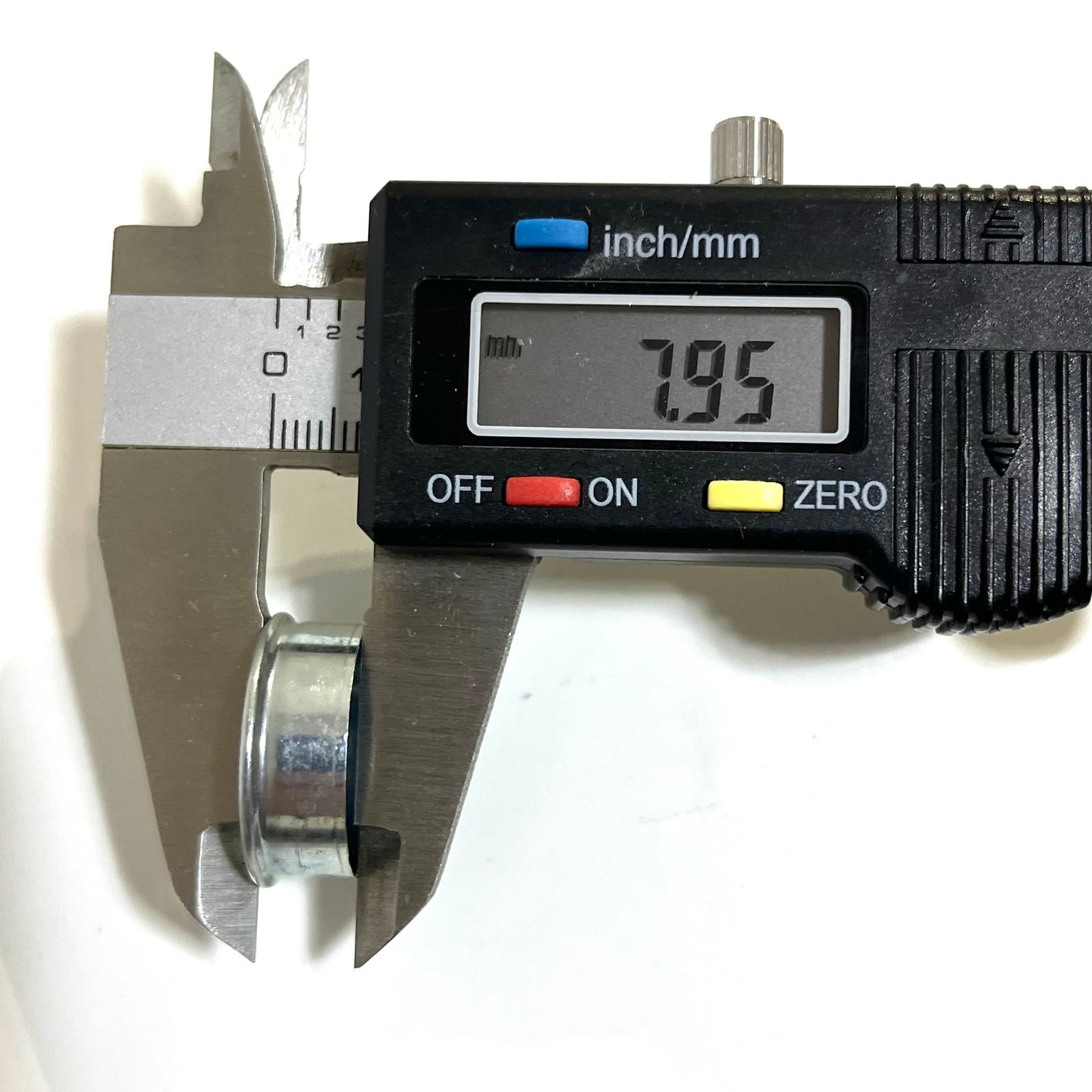 Digital caliper measuring the height of a silver Winchester 12 gauge deprimed steel bottom, reading 7.95mm