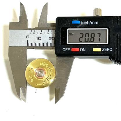 Digital caliper measuring the diameter of a gold brass "Winchester 12 GA" shell head, display reading 20.87mm