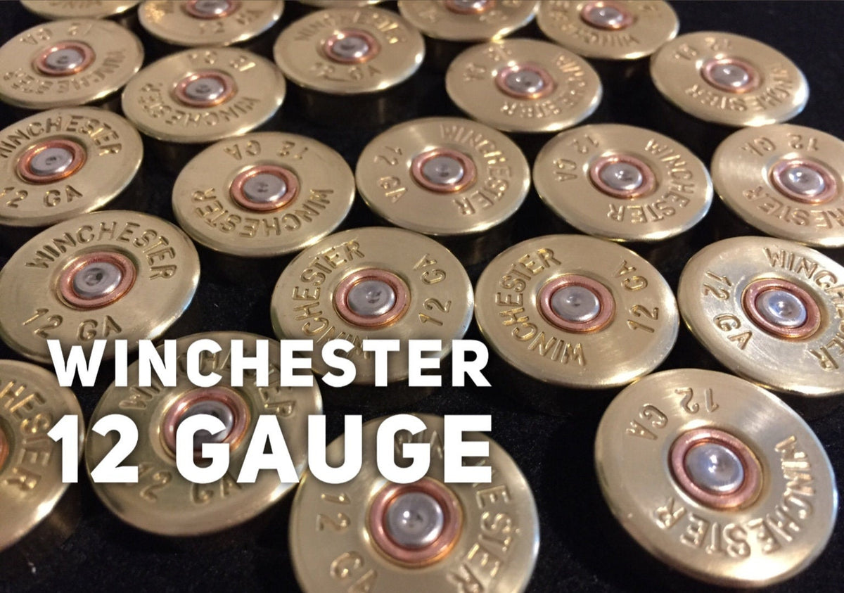 Rows of gold brass shell heads with "Winchester 12 GA" headstamp text on a black background with "Winchester 12 Gauge" text overlay