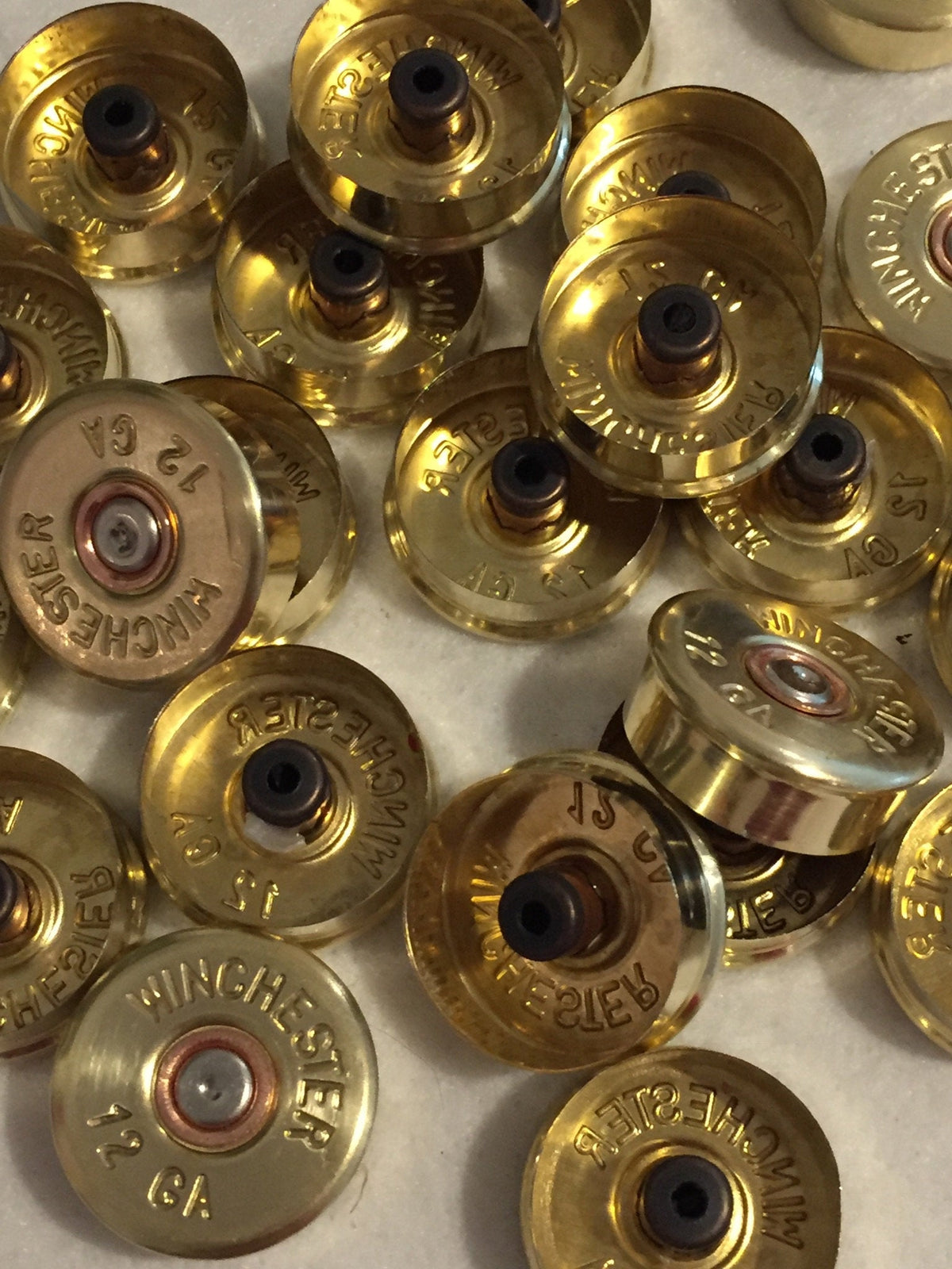 Gold brass shell heads showing hollow primer pockets and "Winchester 12 GA" headstamps, upside-down view
