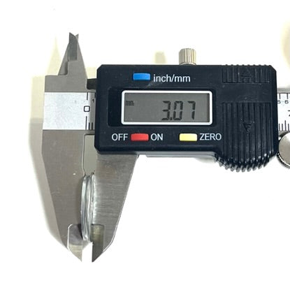 Digital caliper measuring the thickness of a Winchester shotgun shell slice showing 3.07 mm