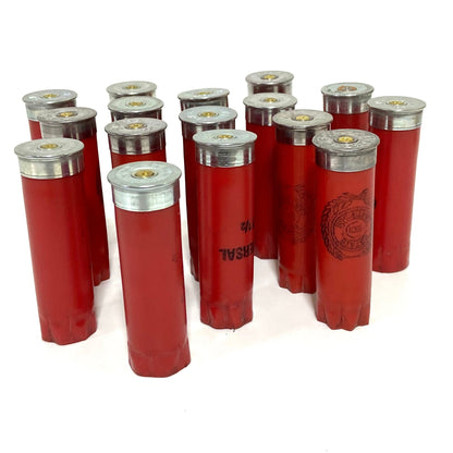 Ten red Winchester 12 gauge hulls standing with silver metal bases angled upward, displaying headstamps and primers.