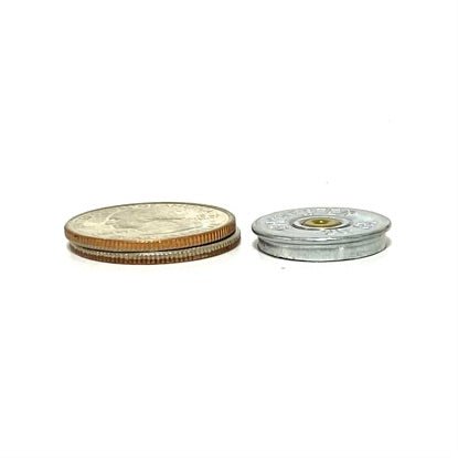 A coin beside a silver 20 gauge shotgun shell slice comparing their heights