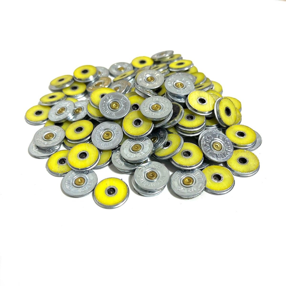 Large pile of silver Winchester 20 gauge shotgun shell slices with yellow rims showing headstamps